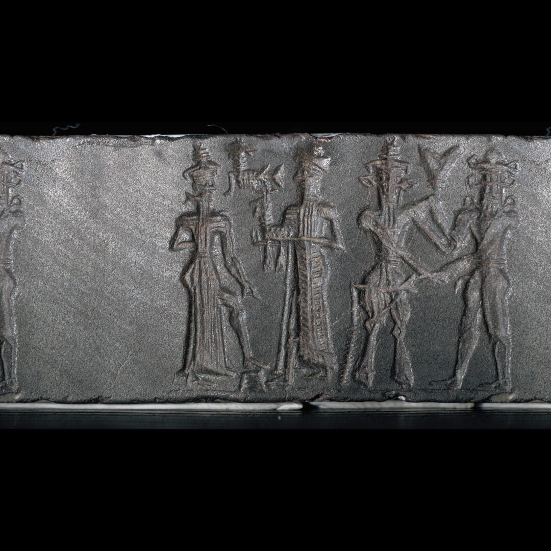Dark stone, cylinder seal, with designs to illustrate article.